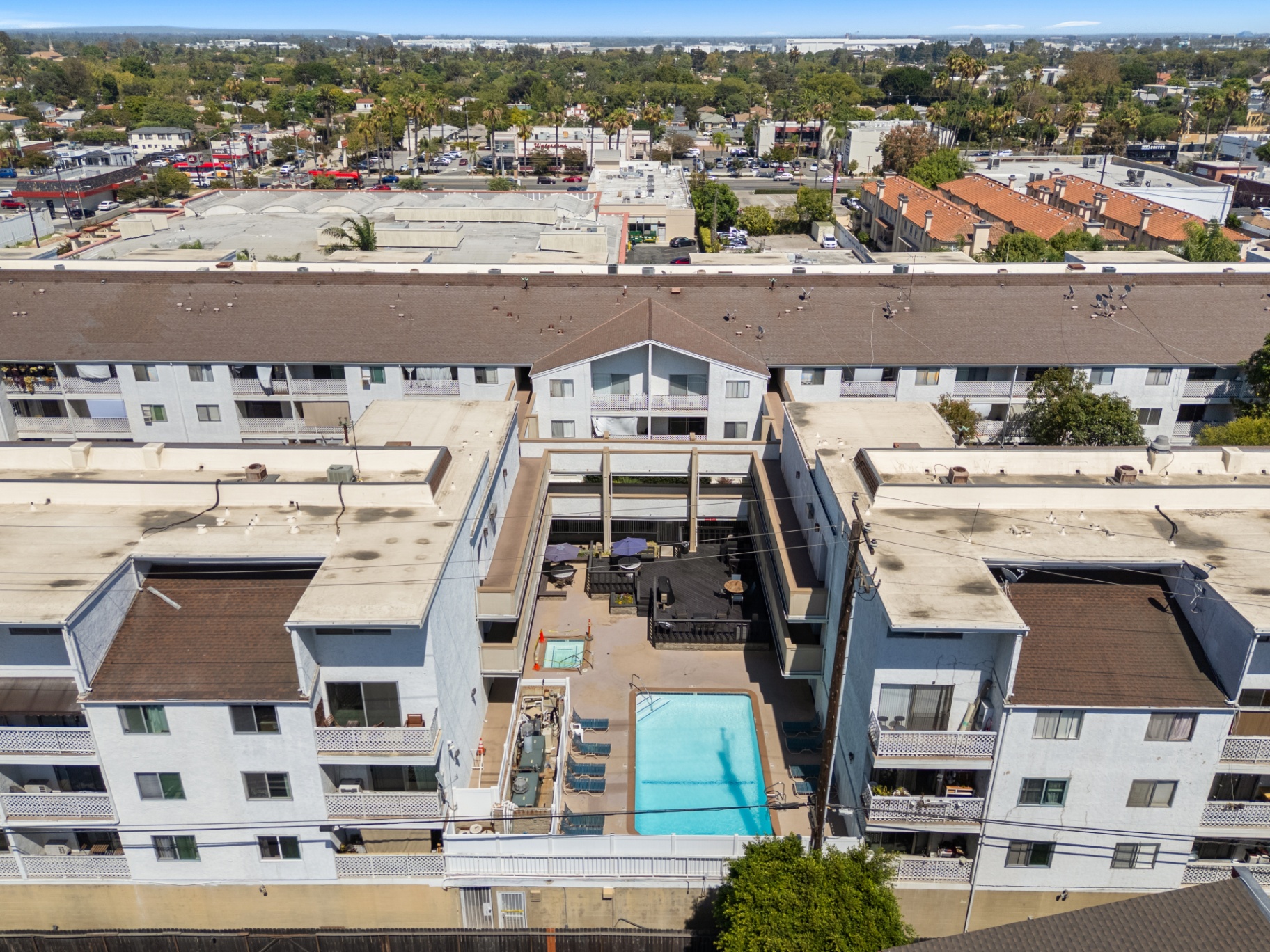 Aerial view of the gated community showing pool, sun deck, and Bixby Knolls surroundings