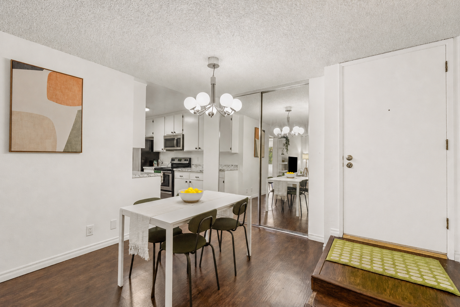 Dining area with globe chandelier, mirrored closet, and front door