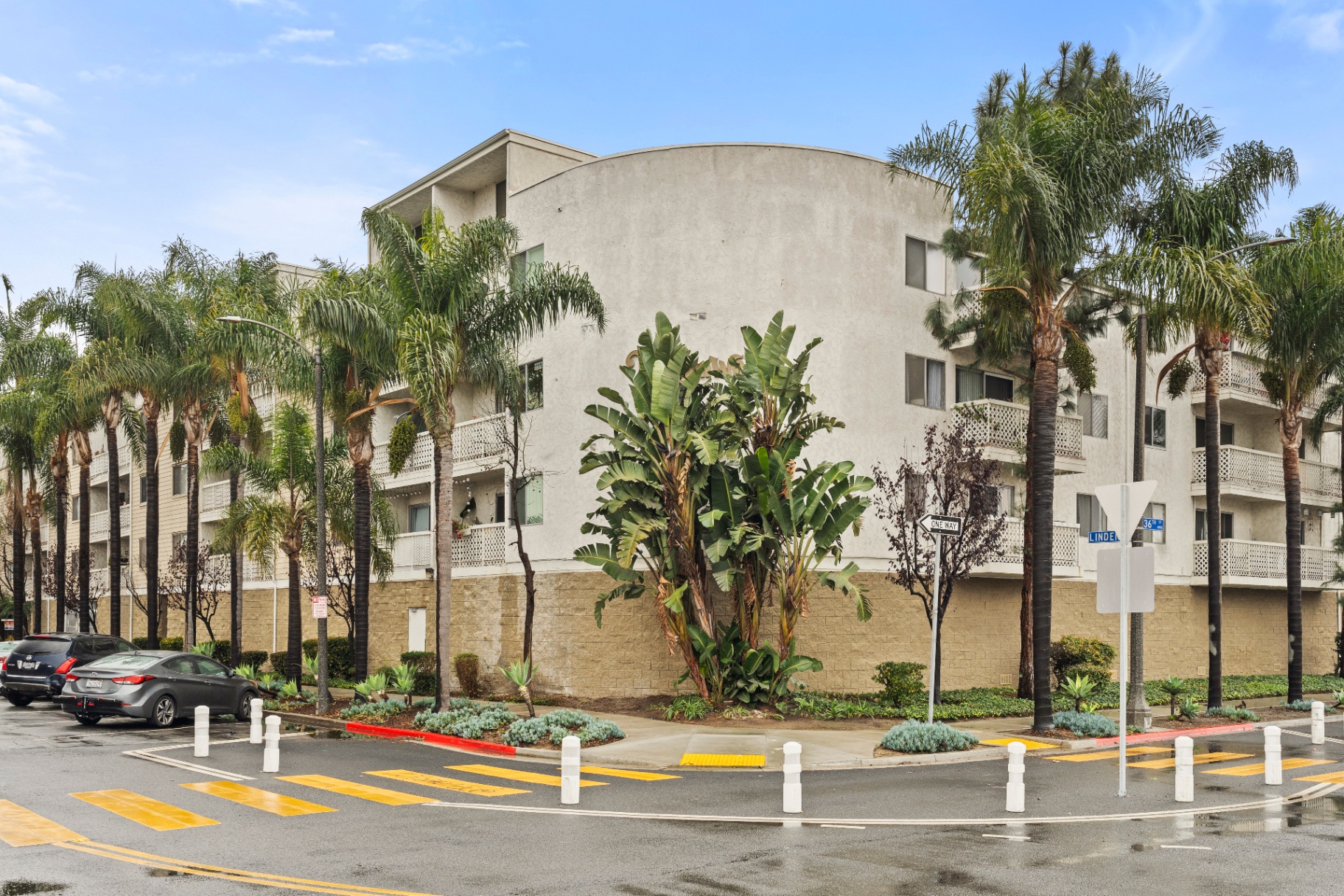 Corner view of the Linden Ave complex at 36th Street with palm-lined sidewalks