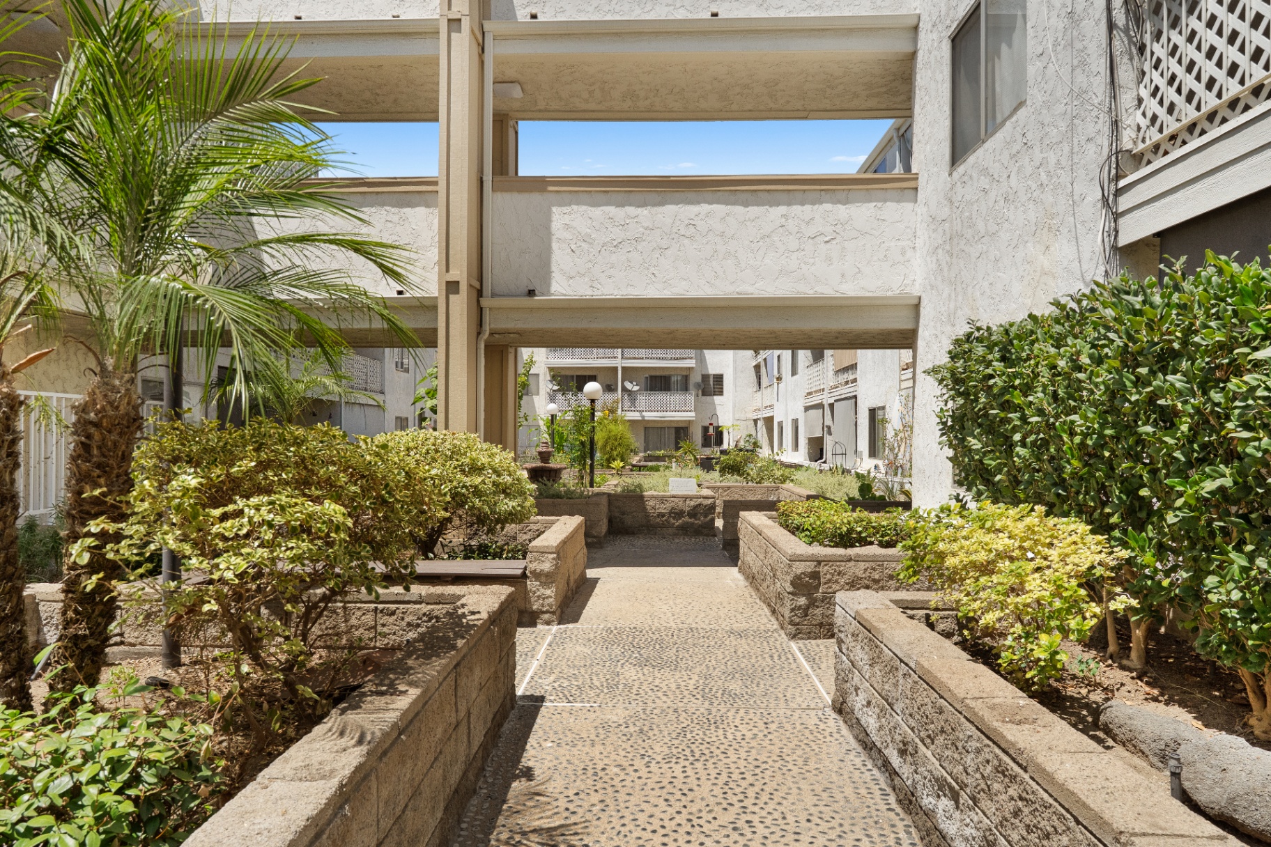 Courtyard with fountain and raised planters between buildings