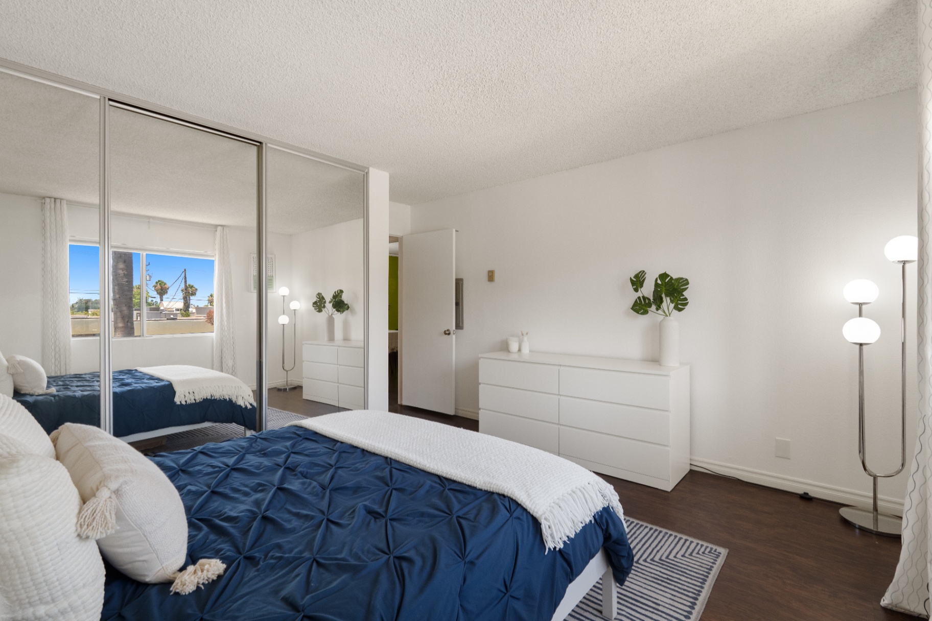 Bedroom showing wall of mirrored closets and second window