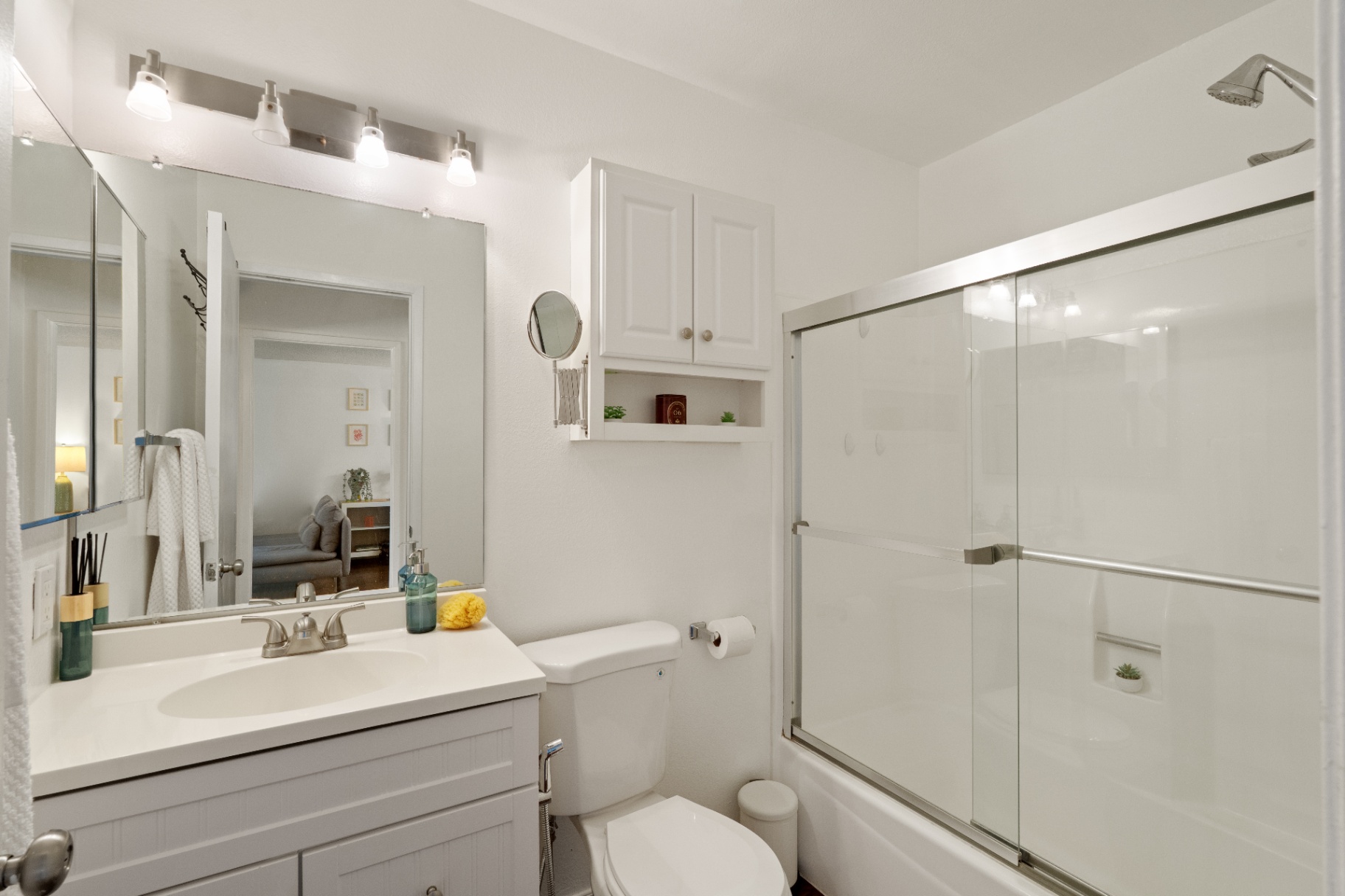 Bathroom with granite vanity, shower over tub, and framed mirror